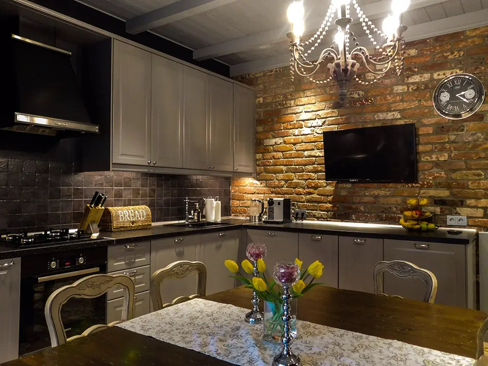 Кухня с кирпичной стеной и массивным обеденным столом