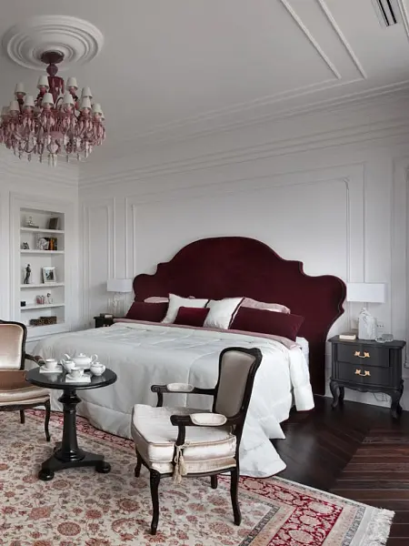 Спальня с бордовой кроватью и винтажными креслами