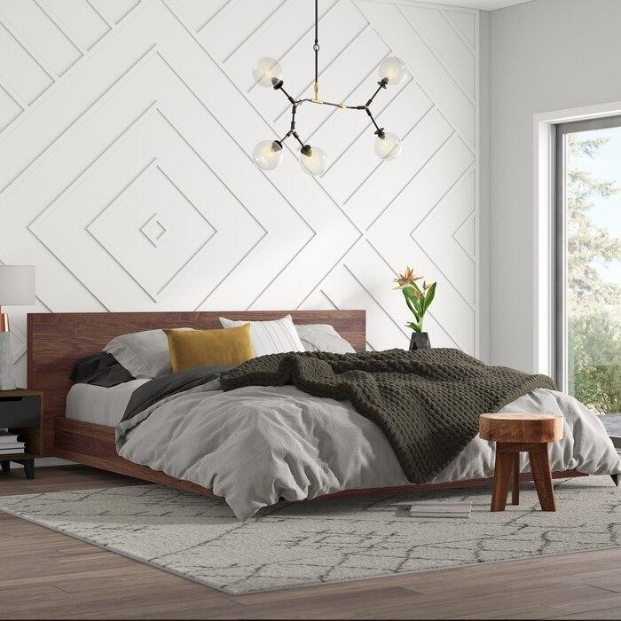 белая спальня с фактурной стеной и деревянной мебелью.jpeg