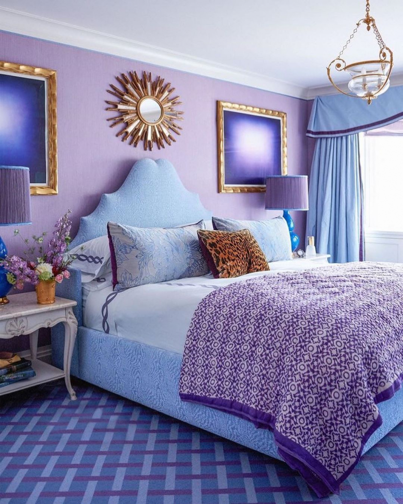 спальня с нежно-сиреневыми стенами, голубой мягкой кроватью и золотым декором.jpg