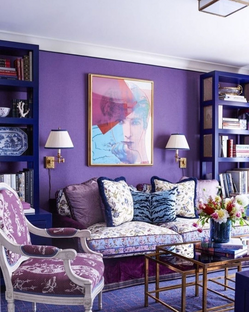 гостиная с фиолетовыми стенами, синими стеллажами и классической мебелью.jpg