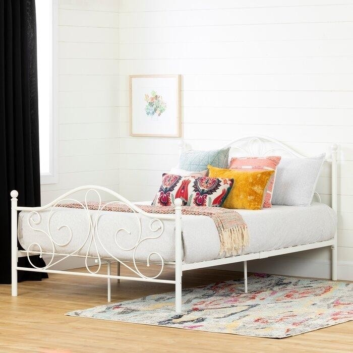 белая спальня в деревянном доме с металлической ажурной кроватью.jpeg