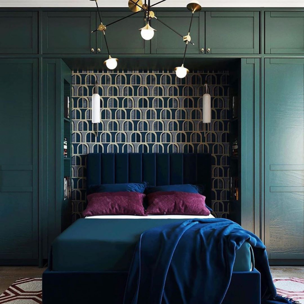 спальня с темно-синей бархатной кроватью, стоящей в нише темно-зеленого шкафа.jpg